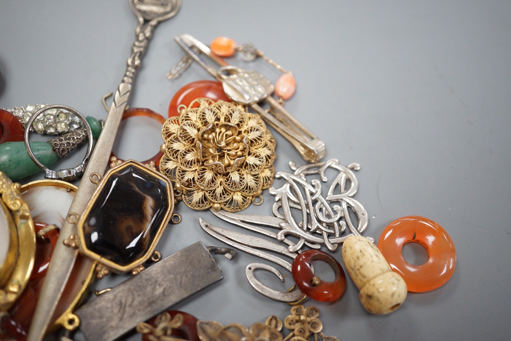 Assorted jewellery including jade pendant, yellow metal buckle brooch, modern silver hinged bangle, cameos, unmounted oval moonstone, agate set white metal buckle brooch, 800 standard paper knife etc.